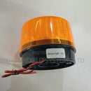 Yellow strobe warning light mounted flat on exterior masonry wall above security alarm box in Kenya