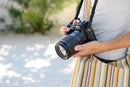Photographer holding a black Nikon Z mirrorless camera equipped with the NIKKOR Z 24-200mm f/4-6.3 VR travel zoom lens outdoors