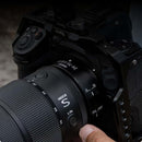 Overhead view of a photographer holding a Nikon Z mirrorless camera equipped with the NIKKOR Z 24-70mm f/2.8 S II lens