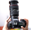 Photographer holding Canon DSLR camera with Viltrox DG-C extension tube mounted