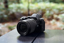Nikon NIKKOR Z 24-105mm f/4-7.1 zoom lens mounted on a black Nikon Z mirrorless camera sitting on a table outdoors